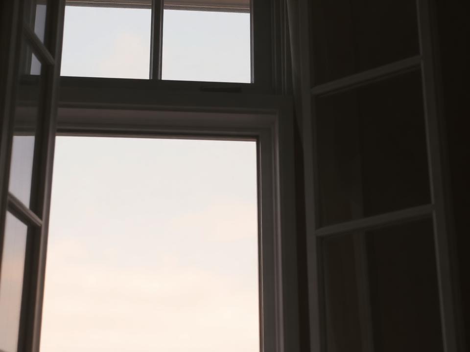 An open window looking out to a pale dawn sky